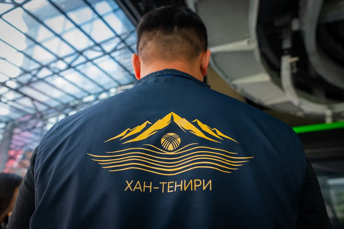 Аркан жолу кызматкеринин курткасынын аркасы: алтын түстөгү тоо жана күн эмблемасы, «Хан-Тенири» жазуусу.